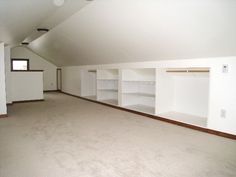 an empty room with white shelves and carpeted flooring in the middle of it