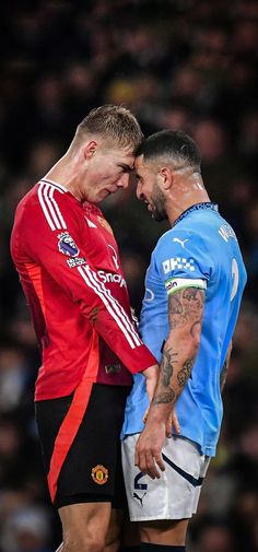 two men standing next to each other on a soccer field