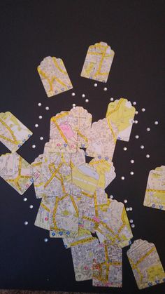 many pieces of yellow and white paper are scattered on the black surface, including small dots