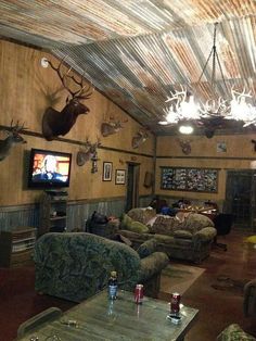 a living room filled with furniture and deer heads on the wall