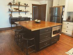 a kitchen island with stools in front of it and an oven on the other side