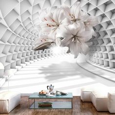 a living room filled with white furniture and flowers hanging from the ceiling over it's walls