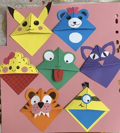 an assortment of paper animals are displayed on a pink board with holes in the middle