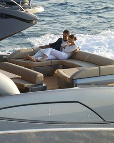 two people sitting on the back of a boat