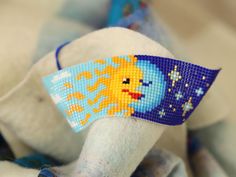 Miyuki Bracelet and Anklet beautifully handcrafted using 1674 pieces of Miyuki beads. The bracelet is dominated with dark and light blue colours where sun is represented both in day and night form. You can see both a blue sky and cotton clouds with a blazing sunny face on the half side and a sleeping half moon with celestial stars. The bracelet is 13cm in length and 3.5 cm in width. The light and dark blue colours on the bracelet can easily be matched with various types of garments. With a free Celestial Style Adjustable Beaded Bracelets With Round Beads, Adjustable Celestial Beaded Bracelets With Round Beads, Handmade Symbolic Beaded Bracelets For Friendship, Handmade Celestial Beaded Bracelets With Round Beads, Handmade Celestial Beaded Bracelets For Gifts, Celestial Style Beaded Bracelets As Gift, Sun And Moon Design, Night Theme, Celestial Stars