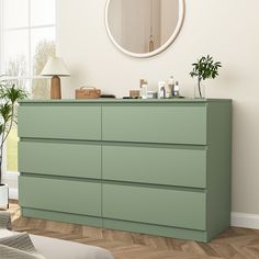 a green dresser sitting in front of a window