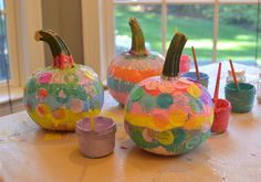 three painted pumpkins sitting on top of a table