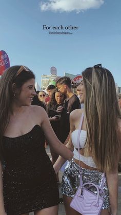 two young women standing next to each other in front of a crowd with the caption for each other