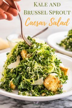 kale and brussels sprout caesar salad on a white plate with a fork