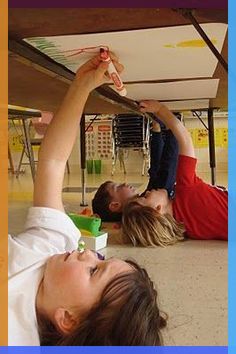 two children laying on the floor with their hands in the air and one child reaching for something