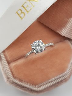 an engagement ring in a box with the word besp written on it's side