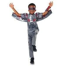 a young boy dressed in silver and red with his arms spread out, wearing an astronaut costume