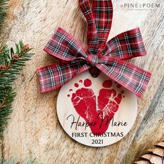 a christmas ornament with a handprinted heart on it and pine cones