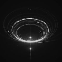 an abstract black and white photo with circles in the center, surrounded by light streaks