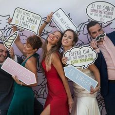 a group of people holding up signs in front of a wall