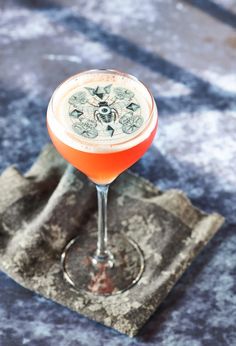 a drink sitting on top of a table next to a napkin