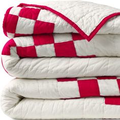 three red and white blankets stacked on top of each other