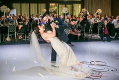 a bride and groom are dancing on the dance floor at their wedding reception in front of an audience