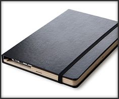 a large black notebook with a pen on top of it and the cover is open