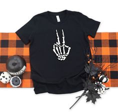 "Halloween Shirt for Women, Skeleton Hands Halloween Shirt, Skeleton Peace Sign Halloween Shirt, Kids Halloween Shirt, Pumpkin Halloween T-shirt ---How To Order --- 1-) Please, check and review all photos 2-) Choose your t-shirt size and color 3-) Write your design color in personalization box 4-) Click add to cart. You can go back to add more product 5-)Click \"Proceed to check out\" 6-)When you check out, you can add a note to seller for any request SIZE AND COLORS: For sizing details and colo Skeleton Peace Sign, Peace Sign Shirt, Peace Sign Shirts, Women Skeleton, Halloween Shirts Kids, Skeleton Shirt, Skeleton Hand, Women Halloween, Skeleton Hands