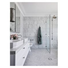 a white bathroom with marble walls and floors