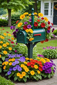 a green mailbox surrounded by colorful flowers