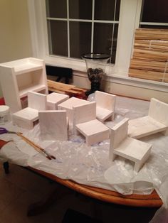 several pieces of white cardboard sitting on top of a table in front of a window