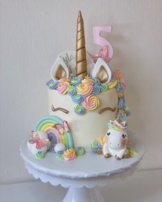 there is a cake decorated with unicorns and rainbows