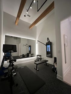 a gym with equipment and mirrors in the background, including a treadmill and television