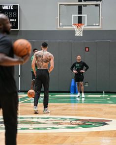 a man standing on top of a basketball court holding a basketball