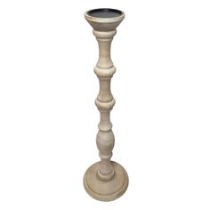 a tall wooden candle holder on a white background