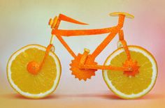 an orange bike with gears on the front wheel