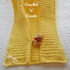 a crocheted blanket with a teddy bear on it