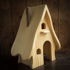 a wooden toy house with a hammer stuck in it