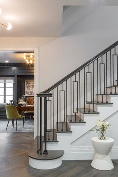 a living room filled with furniture and a stair case next to a dining room table