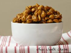 a white bowl filled with nuts sitting on top of a red and white striped napkin