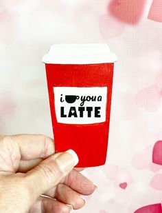 someone holding up a paper cup with the words i love you latte on it