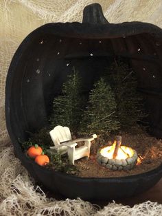 a miniature pumpkin shaped like a chair and fire pit with fake trees in the middle