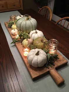 a table with candles and pumpkins on it