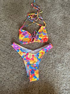 Super cute bright floral print bikini set in comfy fabric. Trendy halter, string top for easy adjusting and cheeky, thong bottom.  Perfect for any occasion! Whether it's the pool, beach, or tanning wear! Multicolor Floral Print Tie-side Swimwear, Adjustable Floral Print Swimwear For Beach Season, Multicolor Adjustable Swimwear For Spring, Adjustable Multicolor Swimwear For Spring, Spring Adjustable Multicolor Swimwear, Spring Multicolor Adjustable Swimwear, Summer Beach Swimwear With Flower Design, Adjustable Floral Print Swimwear For Spring, Colorful Floral Print Swimwear For Vacation