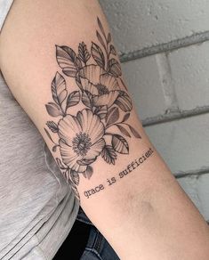 a woman's arm with flowers on it and the words grace is sufficient written in black ink