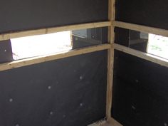 the inside of a building with black walls and wood framing on it's sides