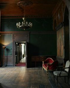 an empty room with two chairs and a chandelier