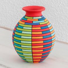 a colorful vase sitting on top of a white table