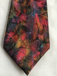 London fashion icon Hardy Amies designed this textured, richly colored multi-colored abstract and floral print tie, with highlights of rust, purple, green. (The picture doesn't do it justice!) I'm not sure of the year, but I know it's vintage. Buy more than one item from me at the same time, and you'll get 10% off all the lower priced items! (Plus save on shipping!) Please take a look at my storefront at: https://www.etsy.com/shop/FabFinds42?ref=seller-platform-mcnav I have a wide selection of o Adjustable Multicolor Neckwear For Gift, Elegant Multicolor Ties As A Gift, Elegant Multicolor Neckwear With Ties, Multicolor Neckwear As A Gift, Multicolor Standard Tie For Summer, Multicolor Summer Ties For Formal Occasions, Elegant Multicolor Standard Tie, Vintage Multicolor Business Ties, Multicolor Accessories For Black Tie Events