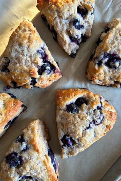 blueberry scones are arranged on a piece of parchment paper and ready to be eaten