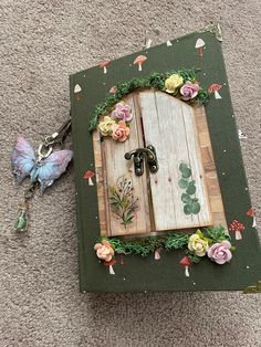 an open book with flowers on it and a keychain laying next to it