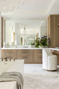 a large bathroom with marble floors and wooden cabinets, along with white bathtubs