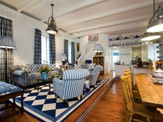 a large open living room with checkered rugs on the floor and wooden tables