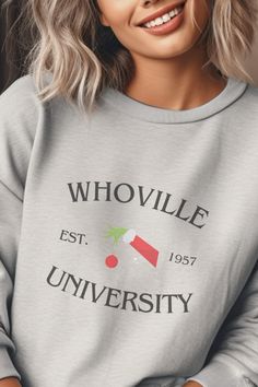 a woman with blonde hair wearing a grey sweatshirt that says whovillee university on it